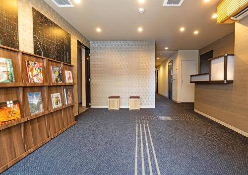a hallway with two stools in a building at Stay SAKURA Kyoto Station Shichijo in Kyoto