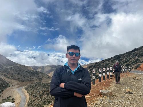 ein Mann steht auf dem Gipfel eines Berges in der Unterkunft Peace guesthouse cottage in Pokhara