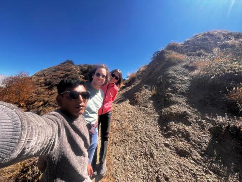 drei Personen stehen an einem Berghang in der Unterkunft Peace guesthouse cottage in Pokhara