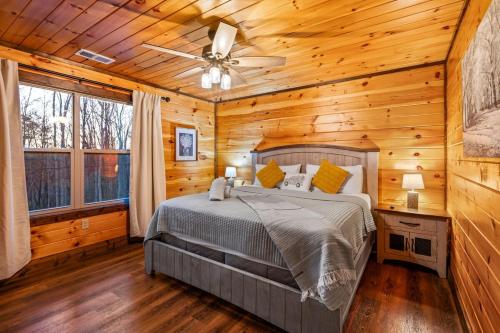 a bedroom with a bed and a ceiling fan at Views, Arcade Game, Fire-pit, Hot Tub, Private! in Sevierville