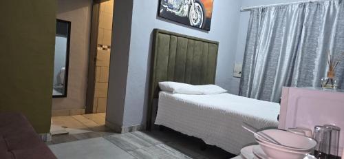 a small bedroom with a bed and a bathroom at Cooper in Potchefstroom