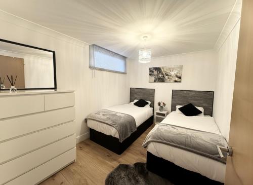 a bedroom with two beds and a dresser and a mirror at Birmingham City Centre 2-Bed with Private Balcony in Birmingham