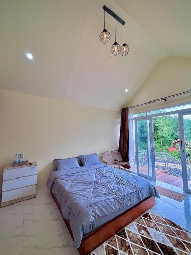 a bedroom with a large bed and a window at Diiza Glamping Tawangmangu in Tawangmangu