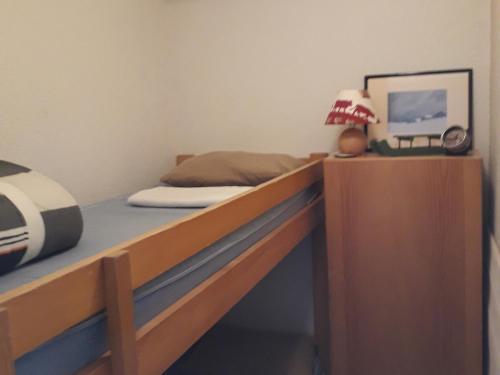 ein Schlafzimmer mit einem Bett und einem Schreibtisch mit einer Lampe in der Unterkunft Studio charmant avec terrasse et parking au Praz de Lys - FR-1-815-19 in Le Praz de Lys