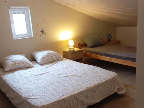 ein Schlafzimmer mit einem weißen Bett und einem Fenster in der Unterkunft Gîte troglodytique typique et cosy pour escapade paisible - FR-1-410-484 in Flée