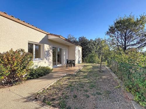 une terrasse couverte d'une maison avec une table et une clôture dans l'établissement Maison climatisée avec parking à Lamalou-les-Bains - FR-1-451-222, à Lamalou-les-Bains