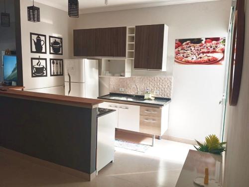 a kitchen with a counter and a pizza on the wall at Cozy air-conditioned house in Sumaré in Sumaré