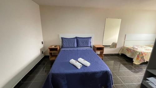 ニテロイにあるCaminho de Itacoatiaraの青いベッドと2枚のタオルが置かれた寝室