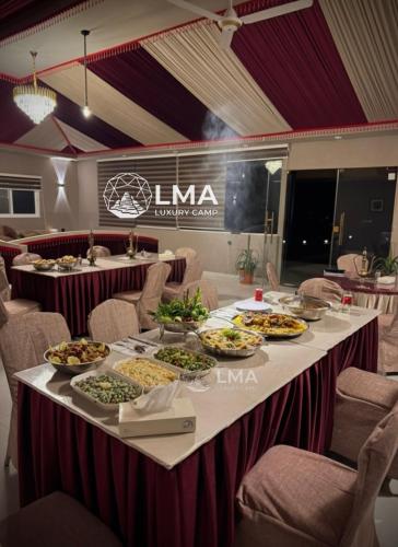a long table with plates of food on it at LMA Rum Luxury Camp in Wadi Rum