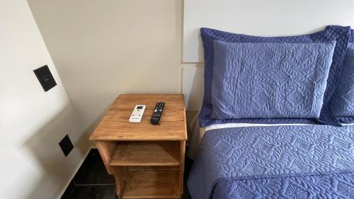 ニテロイにあるCaminho de Itacoatiaraの青いベッドの隣にナイトスタンドがあるベッド