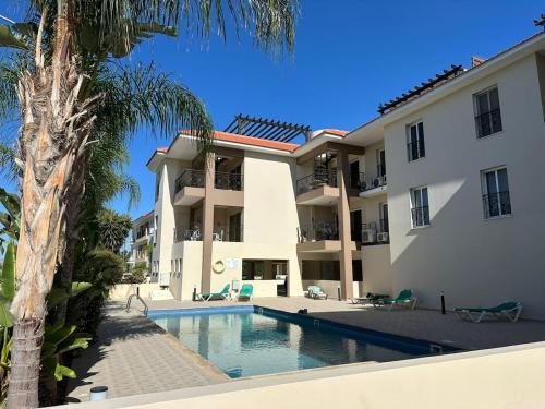 una villa con piscina frente a un edificio en 2 Bedroom Penthouse Apartment With Swimming Pool, en Kiti