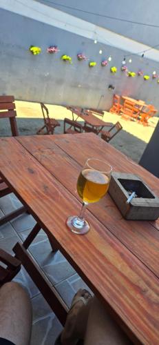 a glass of wine sitting on a wooden table at Hostel Barato Zona Sul in Porto Alegre