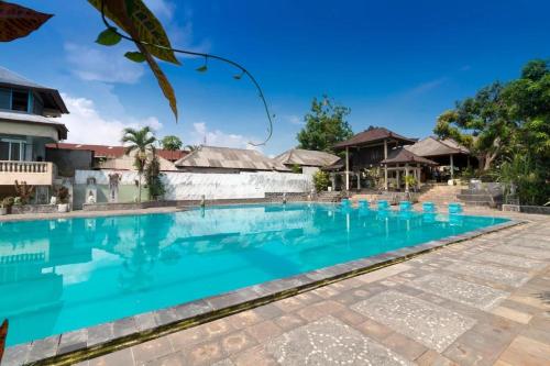 a swimming pool at a resort with blue water at Maha Jaya Hotel Bali in Denpasar