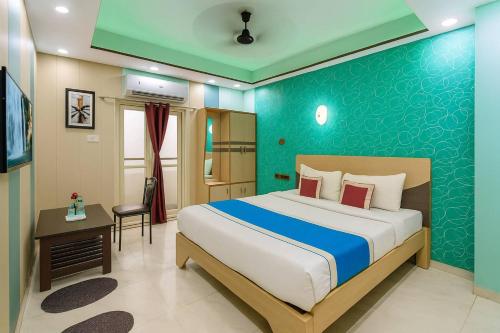 een slaapkamer met een bed en een blauwe muur bij VIP Hotel Residency Puri Inn - Top-Rated Luxury Hotel - Near Sea Beach & Sea Facing Rooms In Puri - AC Rooms #Lift - Free Wi-Fi & Parking - A Best Luxury Hotel Inn Puri Book Now in Puri