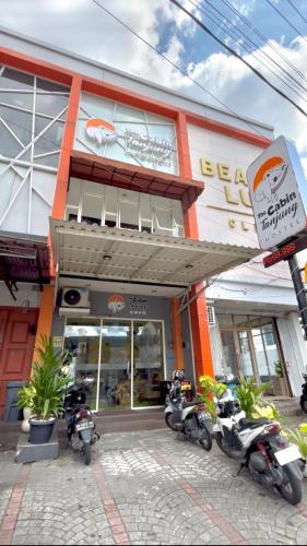 The Cabin Tanjung Yogyakarta في يوغياكارتا: مجموعة من الدراجات النارية متوقفة خارج المبنى