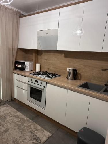 バルツィにあるApartamentのキッチン(白いキャビネット、コンロ、シンク付)