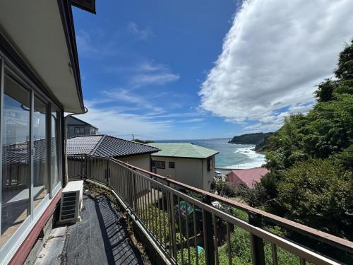 a balcony of a house with a view of the ocean at BlueTree稲取 in Higashiizu