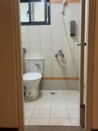 a bathroom with a toilet and a shower at 時光旅舍 in Jincheng