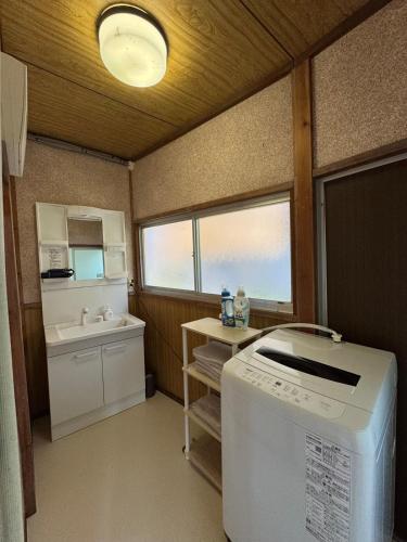 a small kitchen with a washing machine and a sink at BlueTree稲取 in Higashiizu