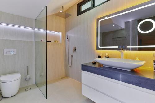 a bathroom with a sink and a toilet and a mirror at Magic suites Seaview villas, Koh Samui in Choeng Mon Beach