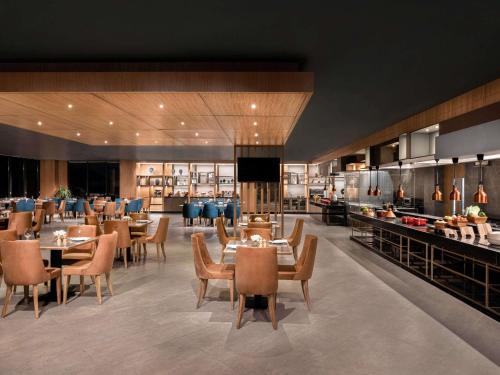 チャンディーガルにあるNovotel Chandigarh Tribune Chowkのテーブルと椅子とビュッフェのあるレストラン