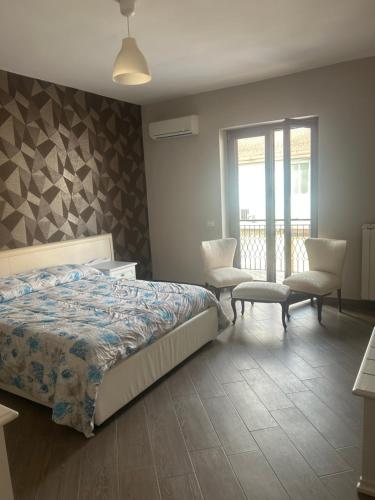 a bedroom with a bed and two chairs and a window at I luoghi di Lisetta in Montefusco