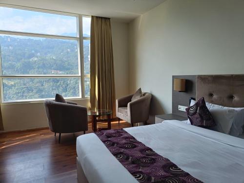 a hotel room with a bed and a large window at Zambala residency & spa in Gangtok