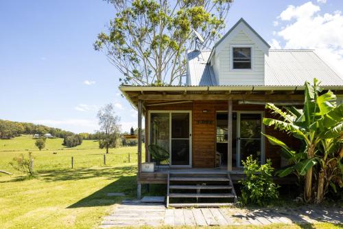a tiny house in the middle of a field at THE MAINSTAY FARMSTAY Unique Aussie Farmstay, Seal Rocks, Barrington Coast in Neranie