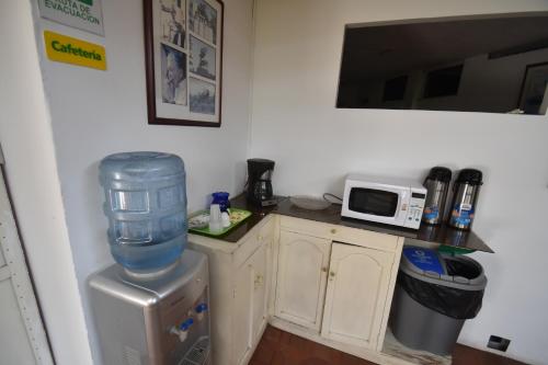 a kitchen with a water cooler and a microwave at Hotel Nuevo Tio in Valledupar