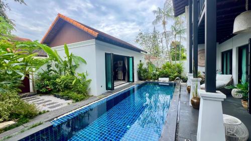 a swimming pool in front of a house at Phuket Hideaway Near Bang Tao in Laguna Phuket