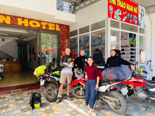 a group of people standing in front of a store with motorcycles at Moon Hotel in Mù Cang Chải