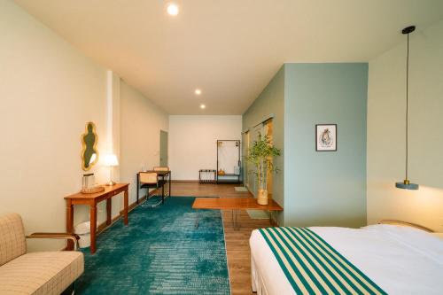 a hotel room with a bed and a couch at Nautical Home & Seashell House B&B in Khao Lak