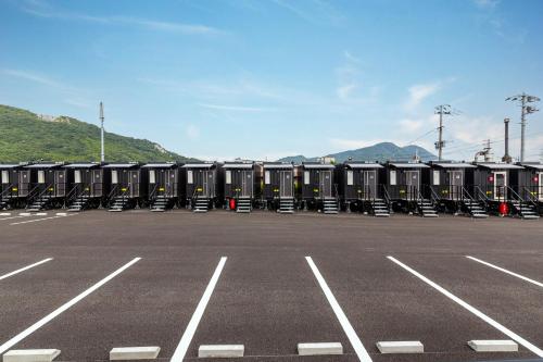 a row of portable toilets in a parking lot at HOTEL R9 The Yard Tagawakawara