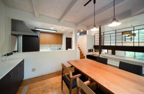 een keuken en eetkamer met een houten tafel en stoelen bij 唐比ステイ in Isahaya