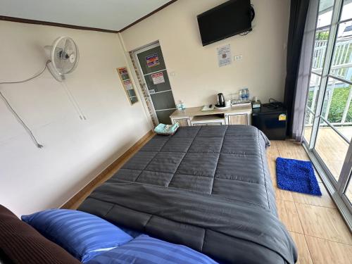 Un dormitorio con una cama grande y un ventilador. en สเตชั่นภูทับเบิก-บ้านดาดฟ้าทะเลหมอก, en Ban Tha Kok Hai