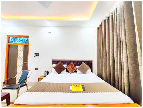 une chambre d'hôtel avec un lit et une chaise dans l'établissement PREMIUM HOTEL MATE-SH-WARI - 500M FROM SHREE RAMJANAM BHOOMI - A Luxurious Stay With Free Parking- Wi-fi & Great Hospitality, à Ayodhya