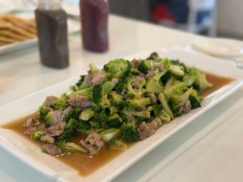 a plate of food with meat and broccoli on a table at Luna Hut Resort in Hua Hin