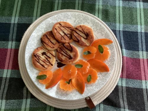 チャルトゥボにあるB&B Villa Maurizioのテーブルの上にクッキーとオレンジが載った皿