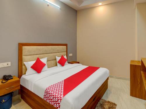 a bedroom with a large bed with red pillows at Hotel O B.S Celebration in Lucknow