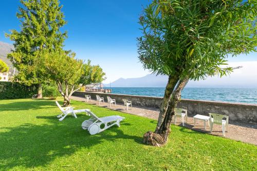 加尔尼亚诺Lake Front Bogliaco - Happy Rentals的公园里,有椅子,有树,还有大海