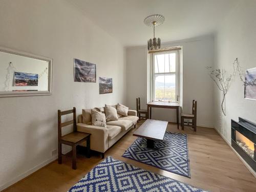 a living room with a couch and a fireplace at Lochside Hermitage in Rashfield
