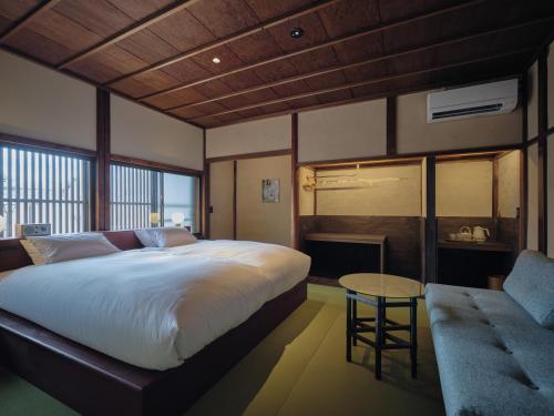 小松市にあるKomado ベンガラのベッドとテーブルとソファのある寝室