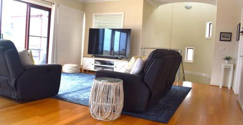 a living room with two chairs and a flat screen tv at Chapel Street Lighthouse in Cowes