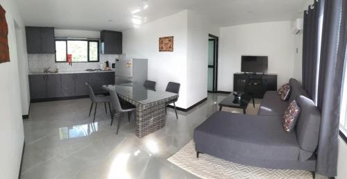 a kitchen and living room with a table and a couch at Lovu Villa in Lautoka