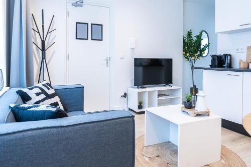 a living room with a blue couch and a white table at Fully Equipped Apartment, lovely bed in Eindhoven