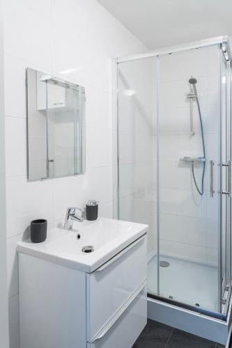 a white bathroom with a sink and a shower at Fully Equipped Apartment, lovely bed in Eindhoven