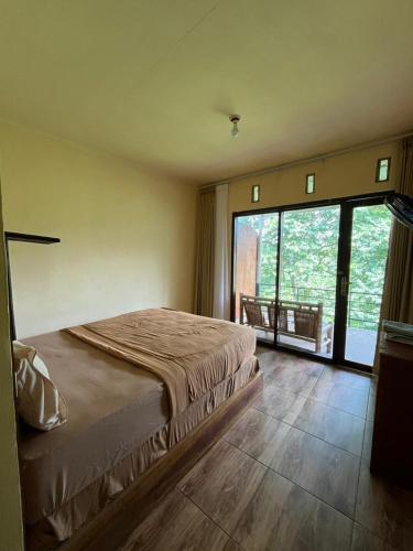 a bedroom with a large bed and a large window at Dragonfly Senaru Lodge in Senaru