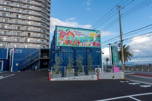 勝浦市にあるHOTEL R9 The Yard Katsuraの建物の隣の駐車場にある大きな看板