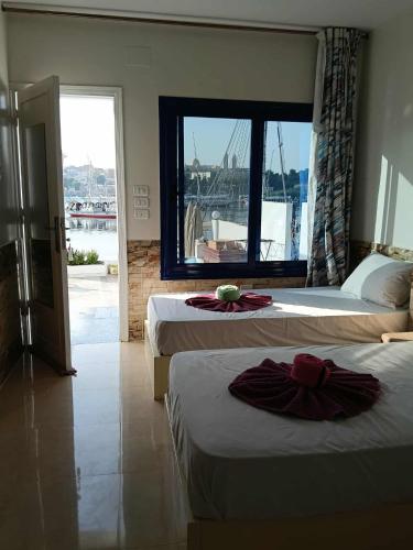 a hotel room with two beds and a window at El-amin Guest House in Aswan
