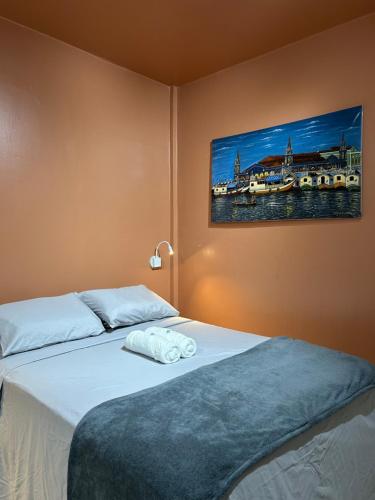 a bedroom with a bed with a painting on the wall at Cantinho da Bandeira in Belém